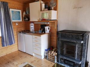 eine kleine Küche mit einem Herd und einem Kühlschrank in der Unterkunft Lakeside cottage Metsäranta Savonranta in Savonranta