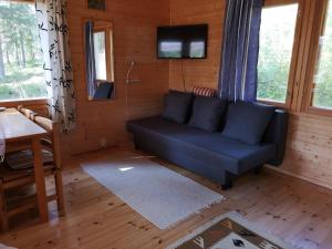 a living room with a blue couch and a tv at Lakeside cottage Metsäranta Savonranta in Savonranta