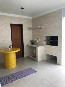 eine Küche mit einem gelben Tisch in einem Zimmer in der Unterkunft Casa Aconchego dos Canyons in Praia Grande