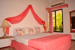 a bedroom with a bed with a red canopy at Cancún Villa Mamey con acceso a Playa in Cancún