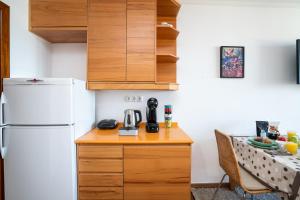a small kitchen with a white refrigerator and a table at *AlgarvianStudio-Vilamoura City Centre* in Vilamoura