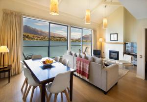 a living room with a table and a large window at Villa Del Lago in Queenstown