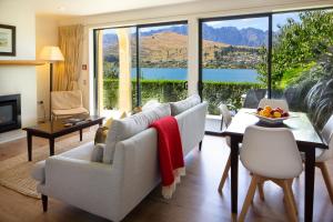 a living room filled with furniture and a large window at Villa Del Lago in Queenstown