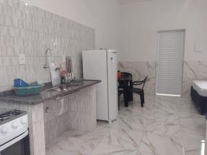 a kitchen with a refrigerator and a counter top at Pousada pesque park 2 in Boracéia