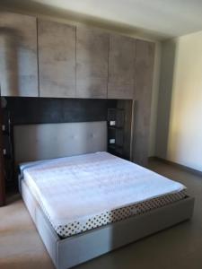 Schlafzimmer mit einem großen Bett mit einem Kopfteil aus Holz in der Unterkunft Castelsardo,Lu bagnu in Castelsardo