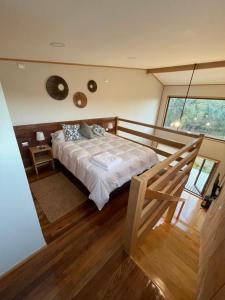 a bedroom with a bed and a large window at Cabañas Arrayanes de Huillinco en Chiloé in Chonchi