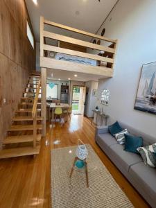 a living room with a couch and a staircase at Cabañas Arrayanes de Huillinco en Chiloé in Chonchi