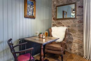 uma mesa e cadeiras num quarto com um espelho em Griffin Inn em Ruthin