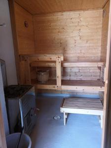 eine Holzsauna mit einer Bank in einem Zimmer in der Unterkunft Lakeside cottage Metsäranta Savonranta in Savonranta + 15 Fotos