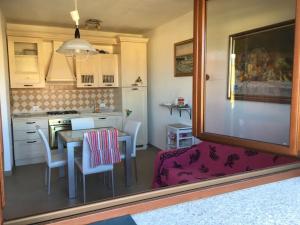 eine Küche mit einem Tisch und Stühlen sowie einem Tisch und einem Spiegel in der Unterkunft Castelsardo,Lu bagnu in Castelsardo