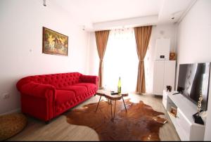 a living room with a red couch and a table at Casa Bella in Ştefăneştii de Jos
