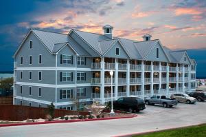 een groot gebouw met auto's geparkeerd op een parkeerplaats bij Holiday Inn Club Vacations Hill Country Resort at Canyon Lake in Canyon Lake