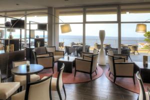 un restaurante con mesas y sillas y vistas al océano en Vitality Hotel Punta en Veli Lošinj