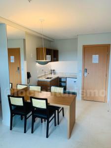 eine Küche und ein Esszimmer mit einem Holztisch und Stühlen in der Unterkunft Apartamento em Resort - Exclusive in Salinópolis