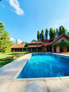 ein großer Pool vor einem Haus in der Unterkunft La Bignonia Posada in Chacras de Coria