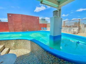 a swimming pool with blue water in a building at Hotel Miami in San Miguel de Tucumán