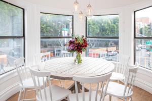 a dining room table with a vase of flowers on it at Hayes Valley Inn in San Francisco