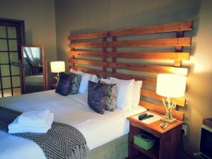 a bedroom with a large bed with a wooden headboard at Midrand Wild Goose Guest House Backup Power in Midrand