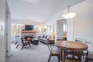 a living room with a table and a fireplace at Tyndall Stone by Outpost Whistler in Whistler