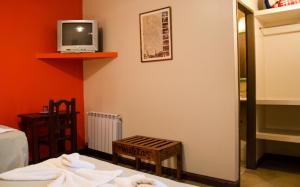 a room with a bed and a tv on a wall at Munay Salta in Salta