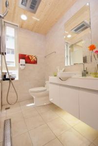 a bathroom with a sink toilet and a mirror at Golden Hotel in Taipei