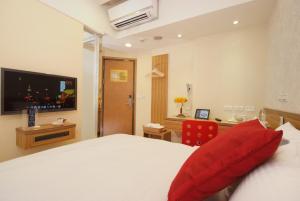 台北市にあるゴールデン ホテルのベッドとテレビが備わるホテルルームです。