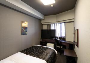 Habitación de hotel con cama, escritorio y TV. en APA Hotel Chiba Chuo Ekimae en Chiba