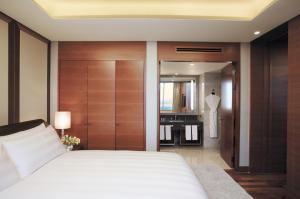 a bedroom with a white bed and a bathroom at LOTTE City Hotel Gimpo Airport in Seoul
