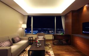 a living room with a couch and a large window at LOTTE City Hotel Gimpo Airport in Seoul