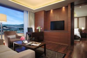 a living room with a couch and a tv at LOTTE City Hotel Gimpo Airport in Seoul