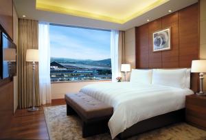 a bedroom with a large bed and a large window at LOTTE City Hotel Gimpo Airport in Seoul