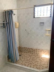 a shower with a shower curtain in a bathroom at Casa Oyamel, Private Room in the heart of cancun in Cancún