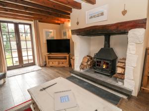 a living room with a fireplace and a tv at Thatchings in Bude
