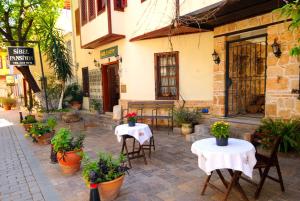 two tables and chairs in front of a building at Sibel Hotel in Antalya