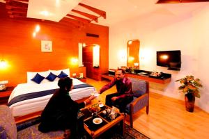 Ein Mann und eine Frau sitzen in einem Hotelzimmer in der Unterkunft Manuallaya The Resort & Spa in Manali