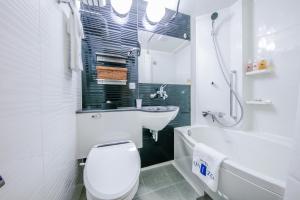 La salle de bains est pourvue de toilettes, d'un lavabo et d'une baignoire. dans l'établissement HOTEL UNIZO Osaka Umeda, à Osaka