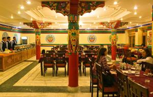 a restaurant with tables and people sitting at tables at Ladakh Residency in Leh