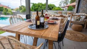 einen Holztisch mit Weinflaschen und Gläsern darauf in der Unterkunft Luxury Country House in Mavrommátion