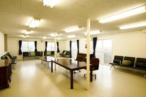 Cette grande chambre comprend une table et des chaises. dans l'établissement 成田スカイパークイン芝山, à Shibayama