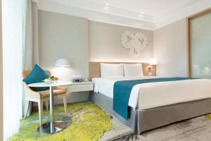 a hotel room with a bed and a desk at Holiday Inn Bangkok, an IHG Hotel in Bangkok