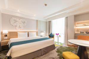 um quarto de hotel com uma cama grande e uma mesa em Holiday Inn Bangkok, an IHG Hotel em Bangkok