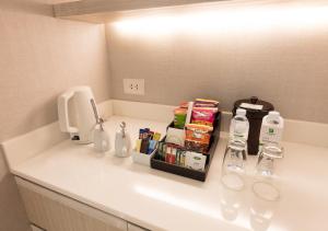 a bathroom counter with a sink with bottles and alcohol at Holiday Inn Bangkok, an IHG Hotel in Bangkok