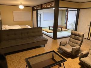 uma sala de estar com um sofá e uma cama em お宿 勝 em Nagiso