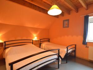 ArimontにあるBalmy Cottage in Baugnez Malmedy with Sauna and Billiardsのオレンジ色の壁の客室内のベッド2台