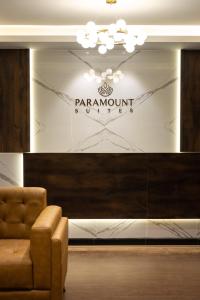 una hall con una sedia e un cartello su una parete di Hotel Paramount Suites & Service Apartments a Mangalore