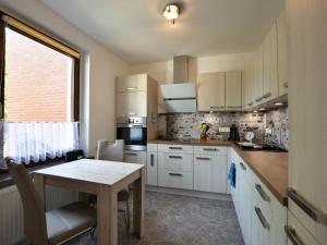cocina con armarios blancos, mesa y ventana en Cozy Apartment in Klutz near Sea, en Klütz