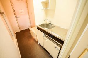 a small kitchen with a sink and a stove at 成田スカイパークイン芝山 in Shibayama