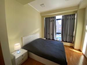 a bedroom with a bed and a large window at Sunny Apartment Dilijan in Dilijan