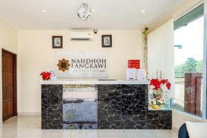 einen Kamin im Wohnzimmer mit einem Schild an der Wand in der Unterkunft Nahdhoh Langkawi Resort in Pantai Cenang