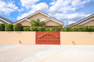 ein Schild für ein Marriott Bankett-Resort vor einem Haus in der Unterkunft Nahdhoh Langkawi Resort in Pantai Cenang